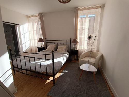 une chambre avec un lit, une chaise et des fenêtres dans l'établissement Chambres cosy au coeur du village, à Chaumont-en-Vexin