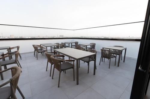 a cafeteria with tables and chairs and a large window at فندق الماسة للأجنحة الفندقية in Tripoli