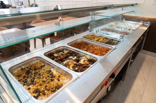a buffet line with many trays of food at فندق الماسة للأجنحة الفندقية in Tripoli