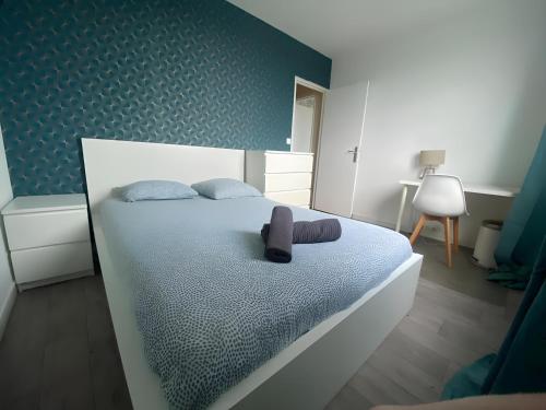 une chambre avec un lit avec un mur bleu dans l'établissement Berlioz Appartement spacieux et lumineux 