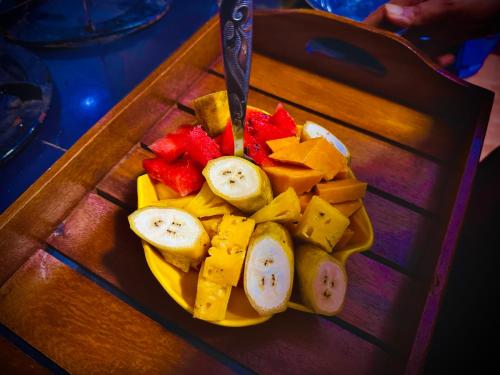 a plate of fruit with a knife on a table at Golden Town Hotel in Tangalle