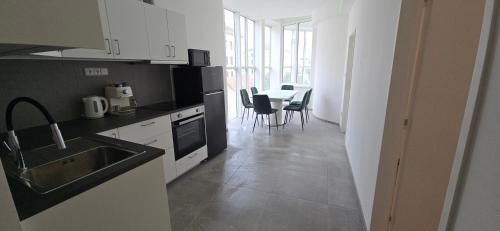 a kitchen with a sink and a table with chairs at Spirit apartments Brno, with parking in Brno