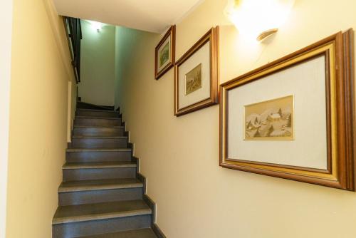 a stairway with pictures on the walls and a stair case at Little Rose garden in Aci Catena