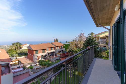 a balcony with a view of a house at Little Rose garden in Aci Catena