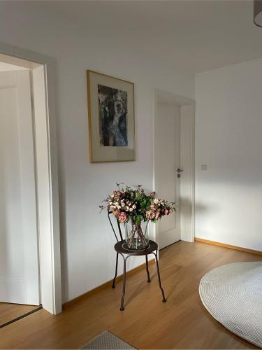 a vase of flowers sitting on a table in a room at Haus KaiserInn - komfortable Wohnung 82 qm TOP ausgestattet, 2 Schlafzimmer mit Balkon und Bergblick in Flintsbach