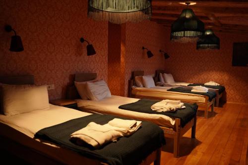 a room with three beds in a room at Hotel Memoire Kutaisi in Kutaisi