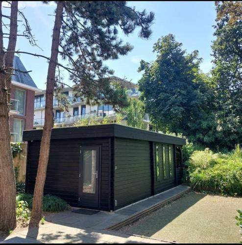 a small green building with a building at Garden House - Free Parking in Scheveningen