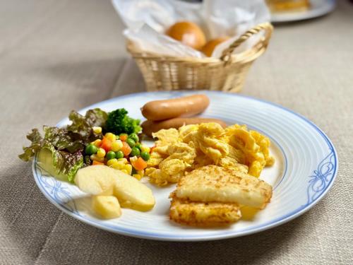 a plate of food with chicken and vegetables on a table at Hotel Sejour Mint in Hakuba in Hakuba