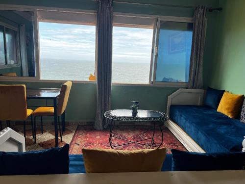 a living room with a couch and a table and a window at Vu sur corniche in Safi