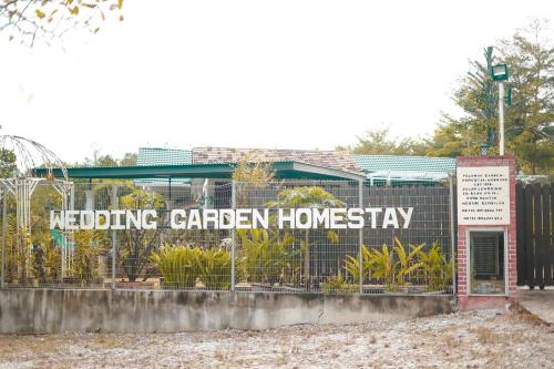a sign on a fence in front of a building at Pelamin Garden Homestay & Wedding in Lengging