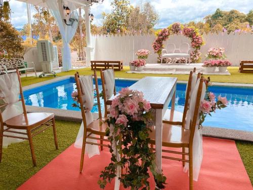 a table and chairs in front of a pool at Pelamin Garden Homestay & Wedding in Lengging