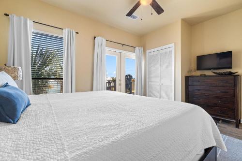 a bedroom with a bed and a flat screen tv at Molokai Villas Riverside 7A in Perdido Key