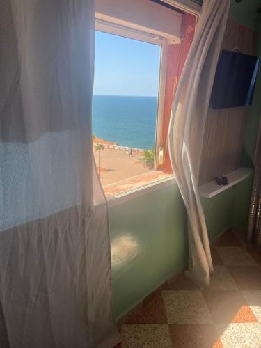 a bedroom with a window with a view of the beach at Vu sur corniche in Safi