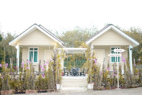 a house with a table and flowers in front of it at Pelamin Garden Homestay & Wedding in Lengging