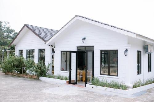 a white house with black windows and doors at Pelamin Garden Homestay & Wedding in Lengging