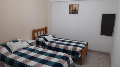 two twin beds in a room with a tv at Viento Zonda in Santa María