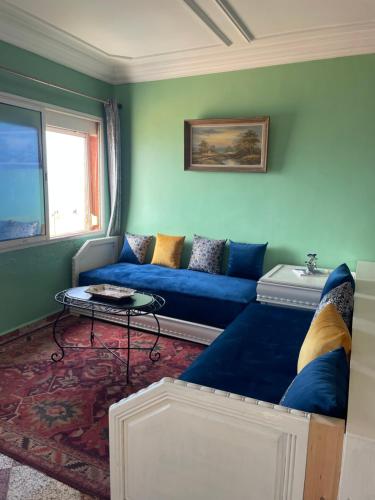 a living room with a blue couch and a table at Vu sur corniche in Safi