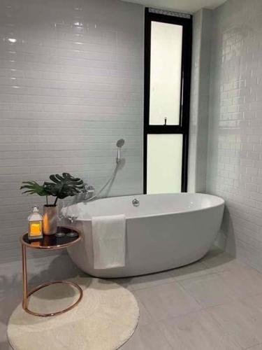 a white bath tub in a bathroom with a table at White Tara Villa in Chiang Mai