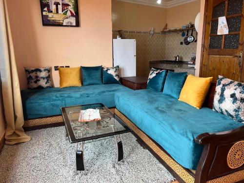a living room with a blue couch and a table at Vu sur corniche in Safi