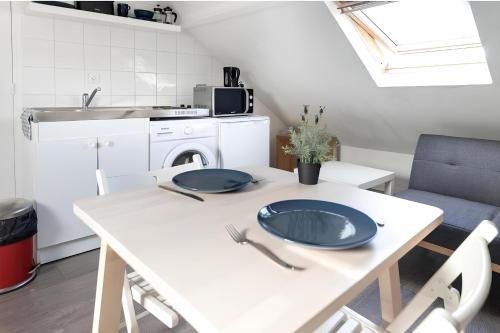 d'une cuisine avec une table blanche et des plaques de cuisson. dans l'établissement CAPUCIN, à Rouen