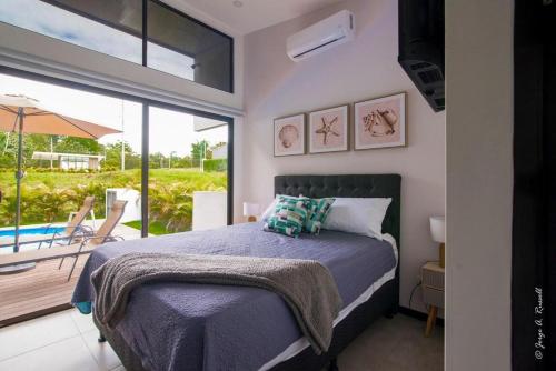 a bedroom with a bed and a balcony with a pool at Casa para Vacacionar Increible en Bejuco in Loma