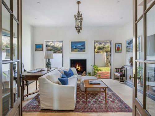 a living room with a white couch and a fireplace at Casa Tranquila Malibu in Malibu