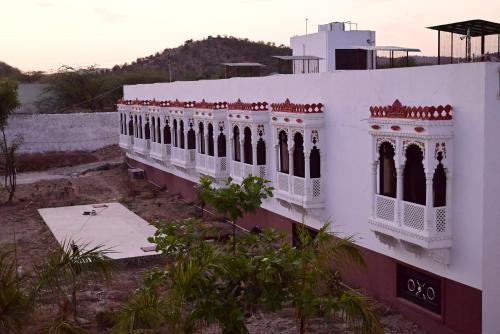 a white building with windows on the side of it at Vijayam Resort in Nāthdwāra