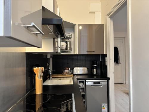 une petite cuisine avec un évier et une cuisinière dans l'établissement Luengoni - 1 chambre - Wifi - Proche Parc Thermal - 2 personnes, à Châtel-Guyon