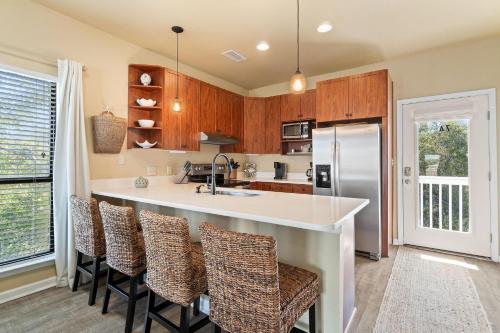 a kitchen with a large island with bar stools at Molokai Villas Riverside 7A in Perdido Key