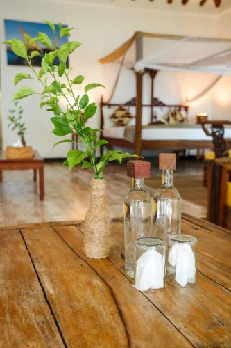 a table with three bottles and a plant on it at Z-Love Zanzibar in Kiwengwa