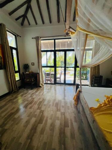 a bedroom with a bed and a large window at Z-Love Zanzibar in Kiwengwa