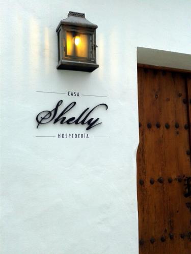 a sign on the side of a building with a light at Casa Shelly Hospedería in Vejer de la Frontera