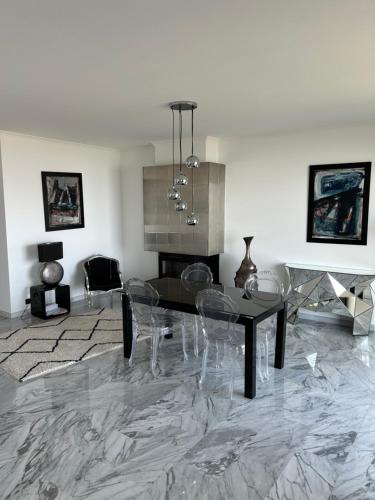 un salon avec une table et des chaises et une cheminée dans l'établissement Somptueux appartement vue mer !, à Cagnes-sur-Mer