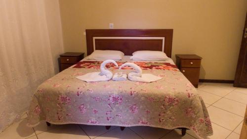 two swans are sitting on top of a bed at Pousada bonomo in Urubici