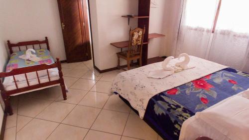 a bedroom with a bed with swans on it at Pousada bonomo in Urubici