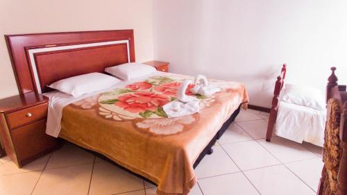 a bedroom with a bed with flowers on it at Pousada bonomo in Urubici