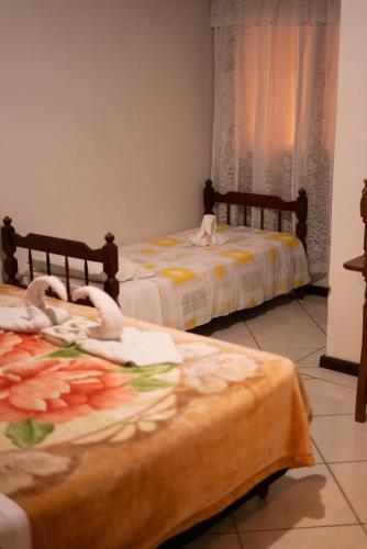 two beds with swans on them in a room at Pousada bonomo in Urubici