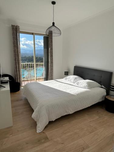 une chambre avec un grand lit et une grande fenêtre dans l'établissement Somptueux appartement vue mer !, à Cagnes-sur-Mer