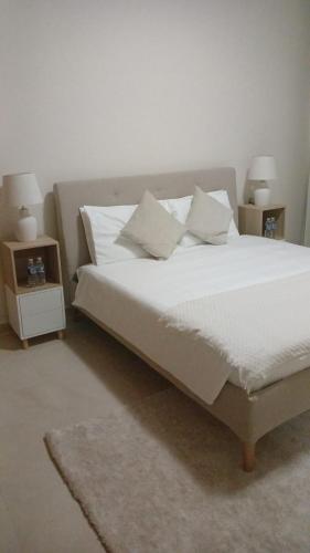 a bed with white sheets and pillows in a bedroom at P one Hotel apartment in Jebel Dhanna