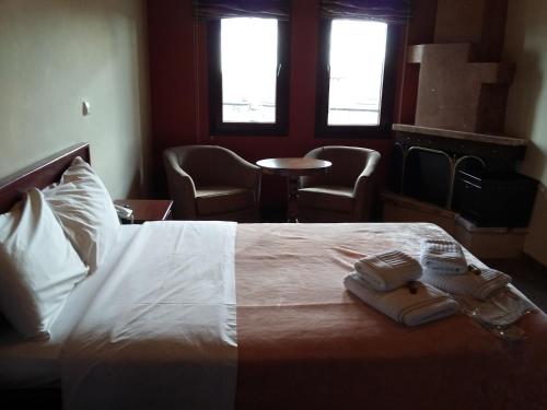 a hotel room with a bed with two towels on it at Voreas Hotel in Kato Loutraki