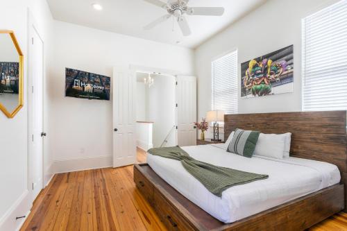 a bedroom with a large bed with a wooden headboard at Amazing 3BR Cottage off St Charles with Pool in New Orleans