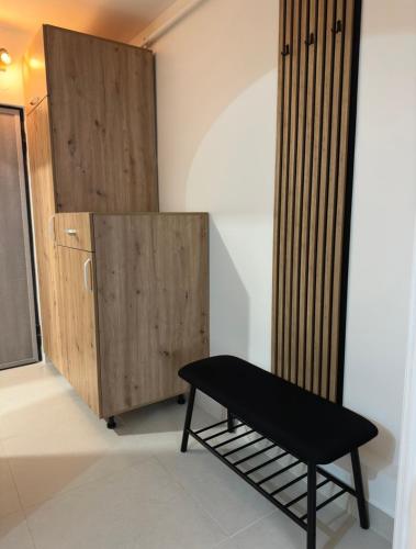 a black bench next to a wooden cabinet at One Room Apartment- Self Check-in 24h in Reşiţa