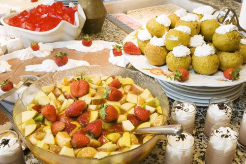 a table topped with plates of fruit and pastries at SBH Monica Beach Resort in Costa Calma