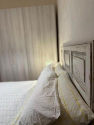 a bed with a white mattress and a wooden headboard at Ocean Pearl in Żonqor