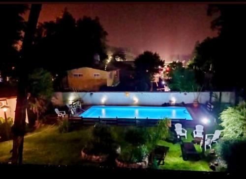 a swimming pool in a yard at night at cabañas el viejo ciprés 3 in Santa Rosa de Calamuchita