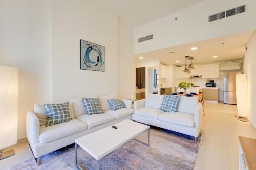 a living room with two white couches and a table at Serene 2-Bed Haven in Jumeirah Golf Estates in Dubai