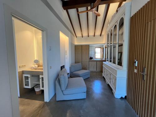 a living room with a blue chair and a desk at Finca Sestelrica in Artá