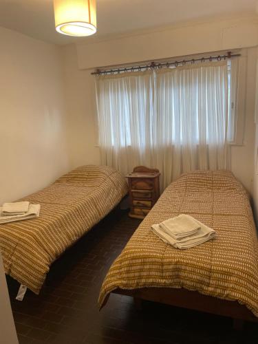 two twin beds in a room with a window at DEPTO MAC in Esquel