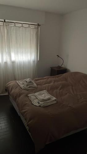 a bed with two shirts on it in a room at DEPTO MAC in Esquel