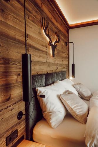 a bedroom with a bed with a wooden wall at Gipfelhaus Magdalensberg in Sankt Veit an der Glan